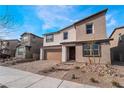 A two-story home with a neutral exterior, two-car garage, simple landscaping, and a paved brick driveway at 785 Black Palace St, Henderson, NV 89011