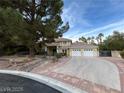 Inviting home exterior featuring a spacious driveway, three-car garage, and mature trees offering shade and curb appeal at 8138 Yucca Springs Dr, Las Vegas, NV 89129
