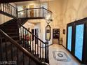 Elegant foyer features a grand staircase, chandelier, and decorative tile, creating a sophisticated first impression at 8138 Yucca Springs Dr, Las Vegas, NV 89129