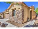 Close-up of a well-maintained home showcasing a stone facade and desert landscaping at 8247 Oasis Bloom St, North Las Vegas, NV 89085