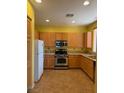 Eat-in kitchen equipped with stainless steel appliances, light wood cabinets, and tile flooring at 8325 Aspen Village St, Las Vegas, NV 89113
