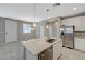 Bright kitchen island featuring a sink, granite countertops, and stainless steel appliances at 8562 Insignia Ave # 102, Las Vegas, NV 89178