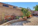 Quaint backyard featuring decorative brickwork, greenery, and a unique bicycle planter at 9065 W Torino Ave, Las Vegas, NV 89148