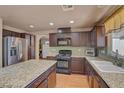 Well-lit kitchen features granite countertops, stainless steel appliances, and dark wood cabinetry at 9065 W Torino Ave, Las Vegas, NV 89148