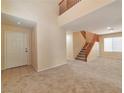 Spacious living room with carpet flooring, neutral paint, and an open staircase, creating a bright atmosphere at 9324 Freedom Heights Ave, Las Vegas, NV 89149