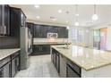 The gourmet kitchen boasts stainless steel appliances, dark wood cabinets, and a large island with a sink at 10742 Cowlite Ave, Las Vegas, NV 89166