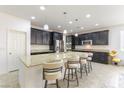 Bright kitchen showcases granite island with seating, stainless appliances, and dark cabinets at 10742 Cowlite Ave, Las Vegas, NV 89166