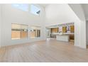 Bright living room featuring soaring ceilings, large windows, and vinyl plank flooring at 10851 Hanwicke Harbor Ave, Las Vegas, NV 89166