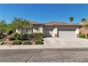 Exterior of a single story home featuring a three car garage and desert landscaping at 11621 La Mirago Pl, Las Vegas, NV 89138