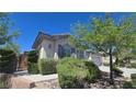 Charming single-story home with arched window, shutters, and lush landscaping at 11621 La Mirago Pl, Las Vegas, NV 89138