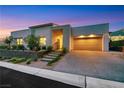 Modern home's exterior features xeriscaping, concrete driveway, and two-car garage at 11895 Skyline Arch Ct, Las Vegas, NV 89138