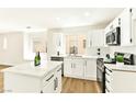 Bright kitchen featuring white cabinets, stainless steel appliances and an island with marble countertops at 1724 Navajo Lake Way, Las Vegas, NV 89128