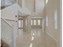 Bright living room with a soaring ceiling, tile floors, large windows, and an open floor plan at 1812 Relate Ct, Las Vegas, NV 89117