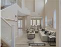 Staged living room with a soaring ceiling, tile floors, large windows, and modern furniture at 1812 Relate Ct, Las Vegas, NV 89117