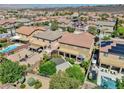 Expansive backyard featuring a pool, patio, lush greenery, and desert landscaping at 2189 De Narvik Dr, Henderson, NV 89044