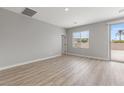 Neutral living room with wood flooring and a sliding glass door providing backyard access and natural light at 3224 Lahontan St, North Las Vegas, NV 89032