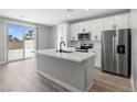 Stylish kitchen features quartz countertops, stainless steel appliances, white cabinets, and a sliding glass door at 3232 Lahontan St, North Las Vegas, NV 89032