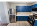 Bright kitchen with blue cabinetry, stainless steel appliances, tile flooring, and a clean, efficient layout at 350 S Durango Dr # 108, Las Vegas, NV 89145