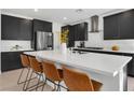 Modern kitchen featuring stainless steel appliances, black cabinets, white countertop and seating at the island at 4246 W Landberg Ave, Las Vegas, NV 89141