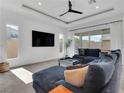 Spacious living room with large sectional sofa, stylish coffee table, ceiling fan, and sliding glass doors at 4246 W Landberg Ave, Las Vegas, NV 89141