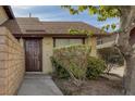 The exterior of a well-maintained townhome showcasing a brown front door and mature landscaping at 4571 Sirius Ave, Las Vegas, NV 89102