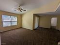 Carpeted living room with a ceiling fan and a large window, providing ample natural light at 555 E Silverado Ranch Blvd # 2147, Las Vegas, NV 89183