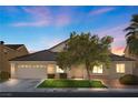 Charming single-story home with a well-manicured front lawn, mature tree, and a two-car garage, under a beautiful sky at 6141 Markleham Ave, Las Vegas, NV 89130