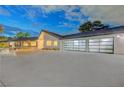 Stunning exterior of a home featuring a three-car garage, stone accents, and modern design in a desirable neighborhood at 7140 Palmyra Ave, Las Vegas, NV 89117