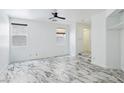Bedroom featuring sleek marble floors, windows for natural light, and a ceiling fan at 7331 Carrot Ridge St, Las Vegas, NV 89139