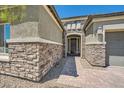 Inviting front entrance with a stone facade, paver walkway, and a dark wood door at 7340 Zonal Ave, Las Vegas, NV 89131
