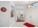 Welcoming foyer featuring tile flooring, chandelier, and a view into a bright room with hardwood floors at 7736 Foredawn Dr, Las Vegas, NV 89123