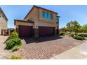 Stunning two-story home featuring a two-car garage and a beautifully paved driveway, surrounded by lush greenery at 7824 Warm Winds St, North Las Vegas, NV 89084