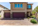 Charming two-story home with a two-car garage and brick-paved driveway, enhanced by meticulous landscaping at 7824 Warm Winds St, North Las Vegas, NV 89084