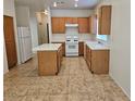Traditional kitchen featuring wood cabinets, a white refrigerator, and a center island at 7849 Blue Brook Dr, Las Vegas, NV 89147