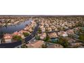 Expansive aerial view of a residential community with a lake and homes with pools and tile roofs at 8100 Lake Hills Dr, Las Vegas, NV 89128