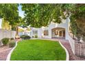 Expansive backyard features lush lawn, mature trees, and a large patio area perfect for outdoor gatherings at 8100 Lake Hills Dr, Las Vegas, NV 89128
