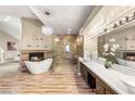 Luxurious bathroom with standalone tub, elegant chandelier, fireplace, glass shower, and dual vanities at 8100 Lake Hills Dr, Las Vegas, NV 89128