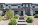 Charming townhome with stone accents, landscaped front yard, and inviting entryway at 835 Jigglypuff Pl, Henderson, NV 89011