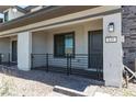 Inviting covered front porch with stone accents and a stylish black metal railing at 835 Jigglypuff Pl, Henderson, NV 89011