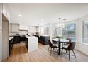 Bright, eat-in kitchen with stainless appliances, white cabinets, black island, and large windows offering a view of the pool at 8401 Airmont Ct, Las Vegas, NV 89128