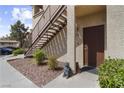 Condo entrance with rock landscaping, stairs, and decorative statue at 8501 W University Ave # 1002, Las Vegas, NV 89147
