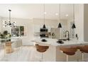 Bright kitchen with white cabinets, modern pendant lights, and an adjacent dining area at 8501 W University Ave # 1042, Las Vegas, NV 89147