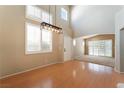 Bright living room with wood floors, modern light fixture, high ceilings, and large windows with shutters at 9360 Canalino Dr, Las Vegas, NV 89134