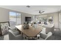 Staged living room featuring lots of natural light, stylish furnishings, modern ceiling fan, and a neutral color palette at 10201 Premia Pl, Las Vegas, NV 89135