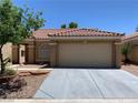 Inviting single-story home with a tile roof, well-maintained landscaping, and a two-car garage at 1712 Matador Way, Las Vegas, NV 89128