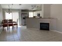 Open floor plan with a dining area, fireplace, tile flooring, stainless steel appliances, and backyard view at 1712 Matador Way, Las Vegas, NV 89128