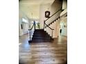 View of staircase with black and white banister, carpeted stairs, and wood floors at 2016 Catalina Marie Ave, Henderson, NV 89074