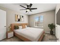 Cozy bedroom features a ceiling fan, a window and a large TV mounted on the wall at 2200 S Fort Apache Rd # 1033, Las Vegas, NV 89117