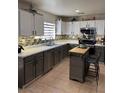Well-equipped kitchen with stainless steel appliances, gray cabinetry, mosaic backsplash, and a functional kitchen island at 2229 Steele St, Las Vegas, NV 89156