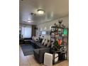 Inviting living room featuring tile floors, neutral walls and a comfortable sectional sofa with decorative shelving at 2229 Steele St, Las Vegas, NV 89156